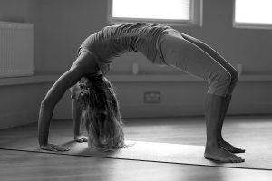Barefoot yoga instructor performing bridge pose