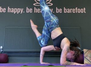 Charlie Haslam in an arm balance at Barefoot Birmingham Yoga